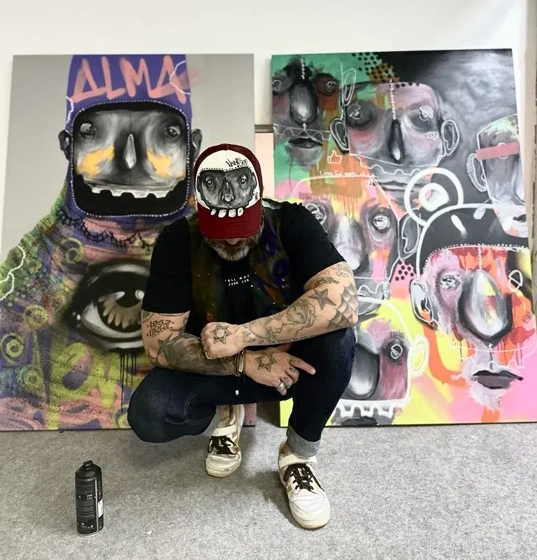 Tico Canato diante de obras da exposição Oculto