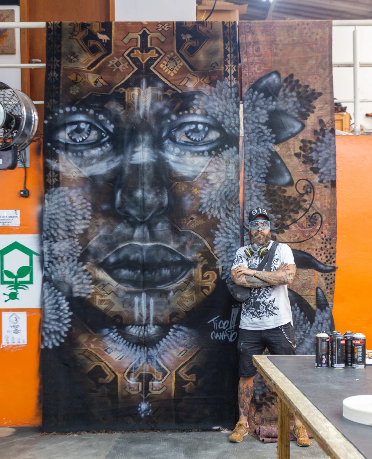 Tico Canato ao lado de sua pintura sobre um tapete persa na colaboração com a by Kamy